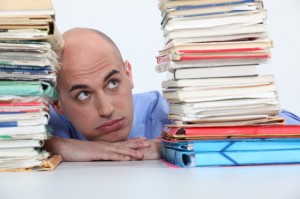 man overwhelmed looking at folders