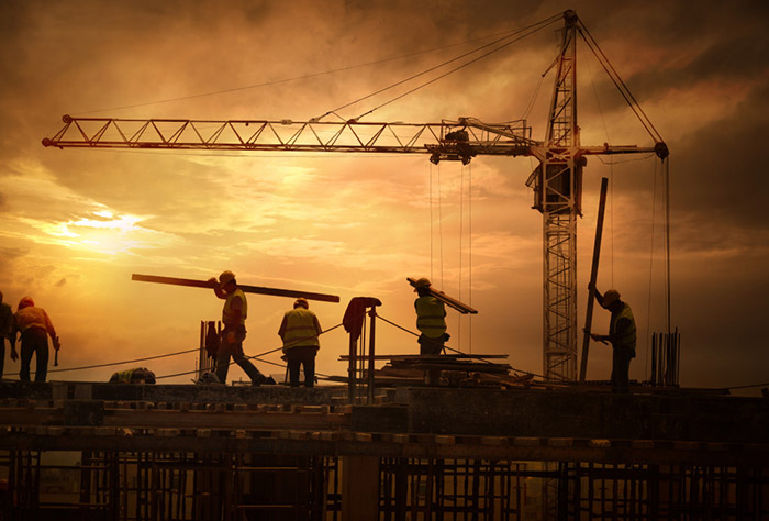 workers on construction platform at sunset