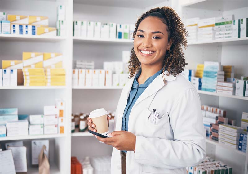 Pharmacist, phone or portrait of woman with coffee texting in pharmacy to contact email or online chat. Social media, happy or doctor on mobile app, typing or searching medical news on tea break.